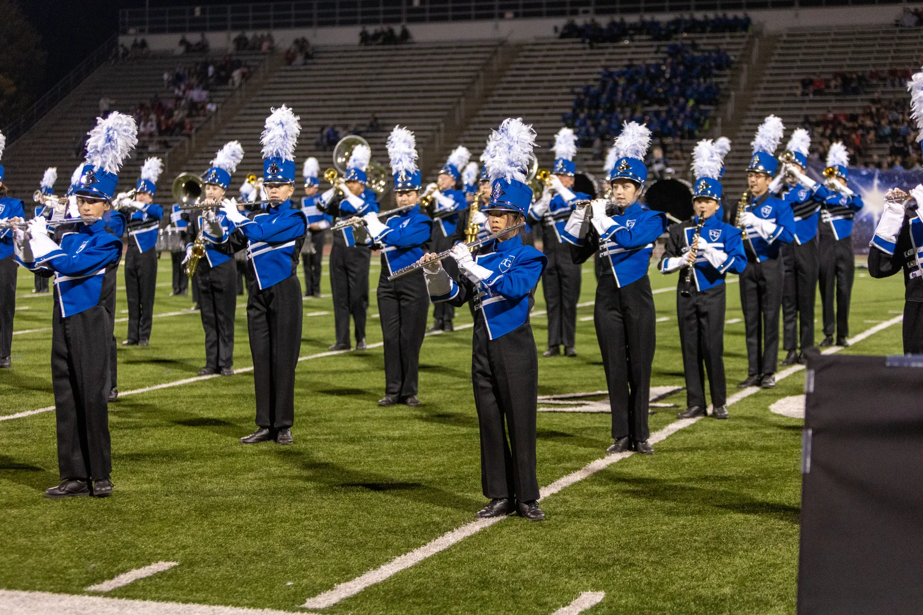 Marching band performing under stadium lights