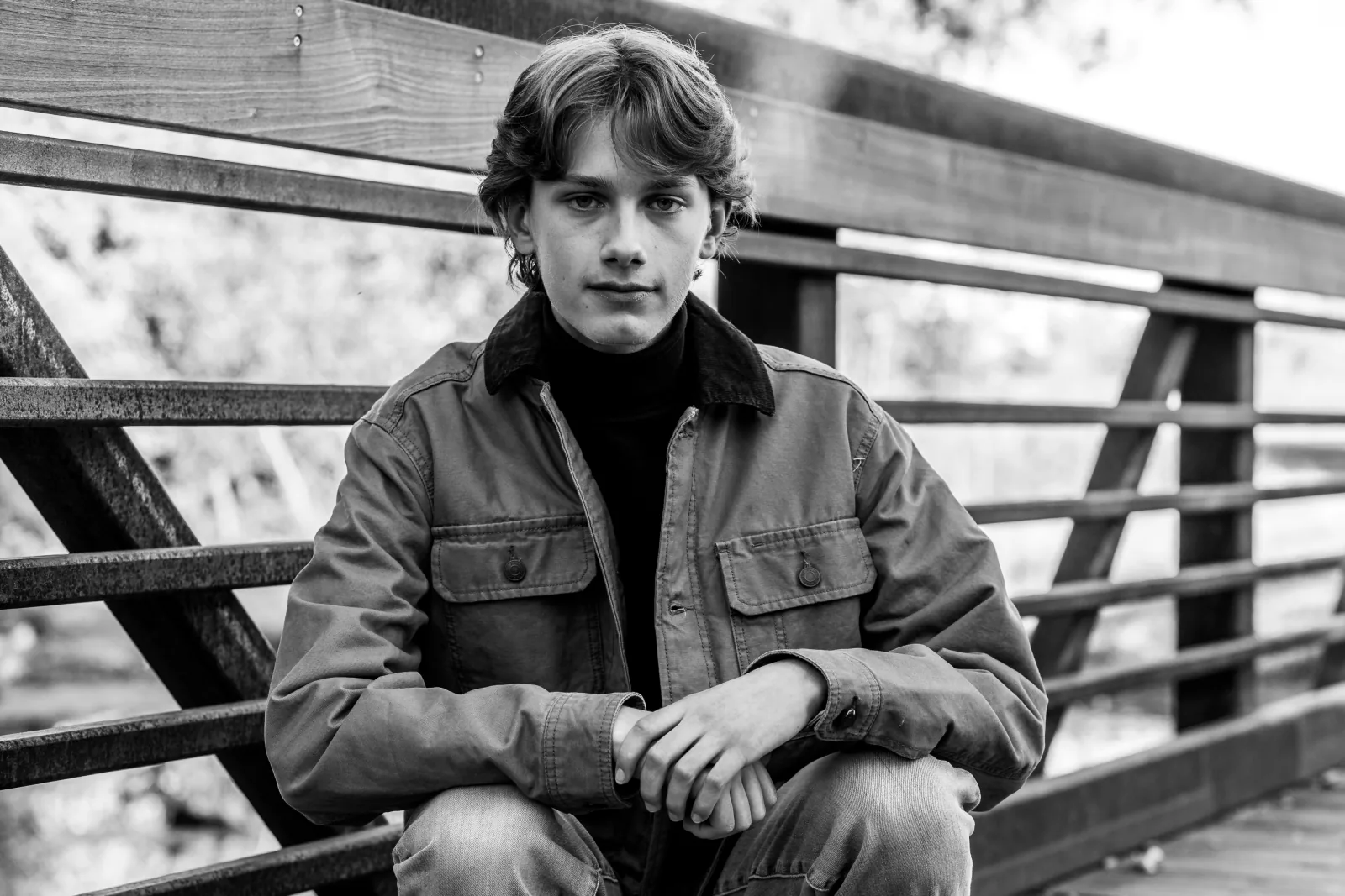 Black-and-white senior portrait on a pedestrian bridge
